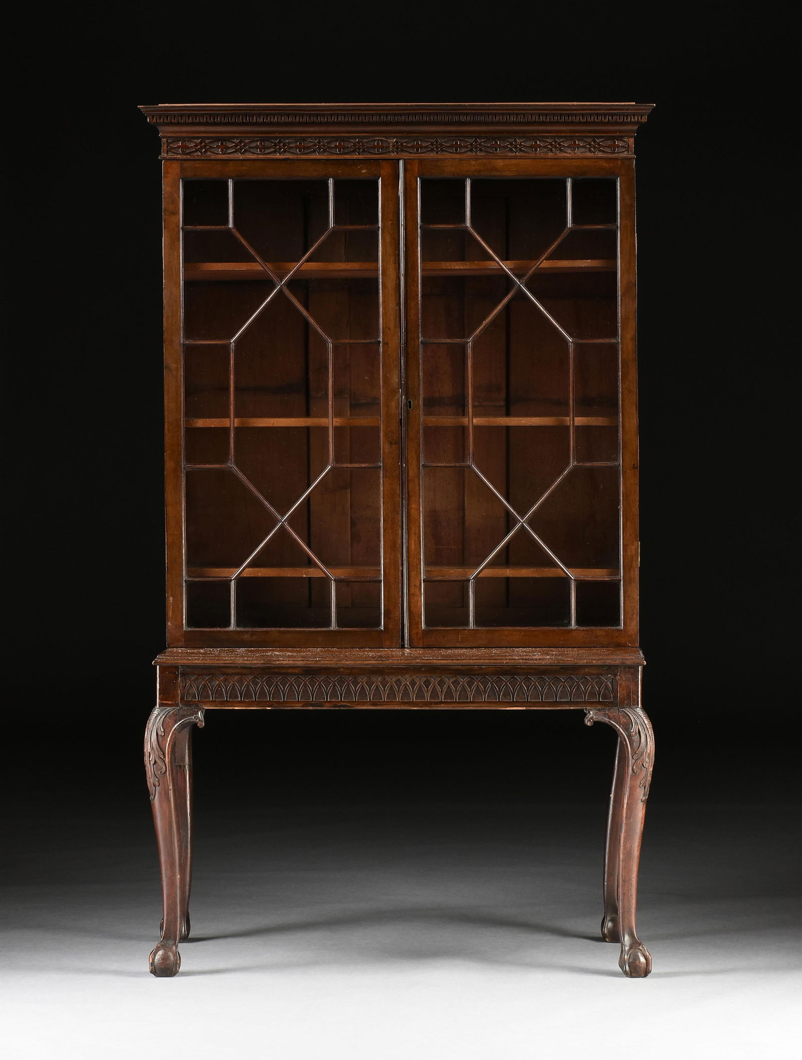 A GEORGE II STYLE MAHOGANY ASTRAGAL GLAZED CLAWFOOT BOOKCASE ON STAND, ENGLISH, 19TH CENTURY: A GEORGE II STYLE MAHOGANY ASTRAGAL GLAZED CLAWFOOT BOOKCASE ON STAND, ENGLISH, 19TH CENTURY, a subdued variation of Thomas Chippendale's late 18th century designs, the molded cornice over two glazed