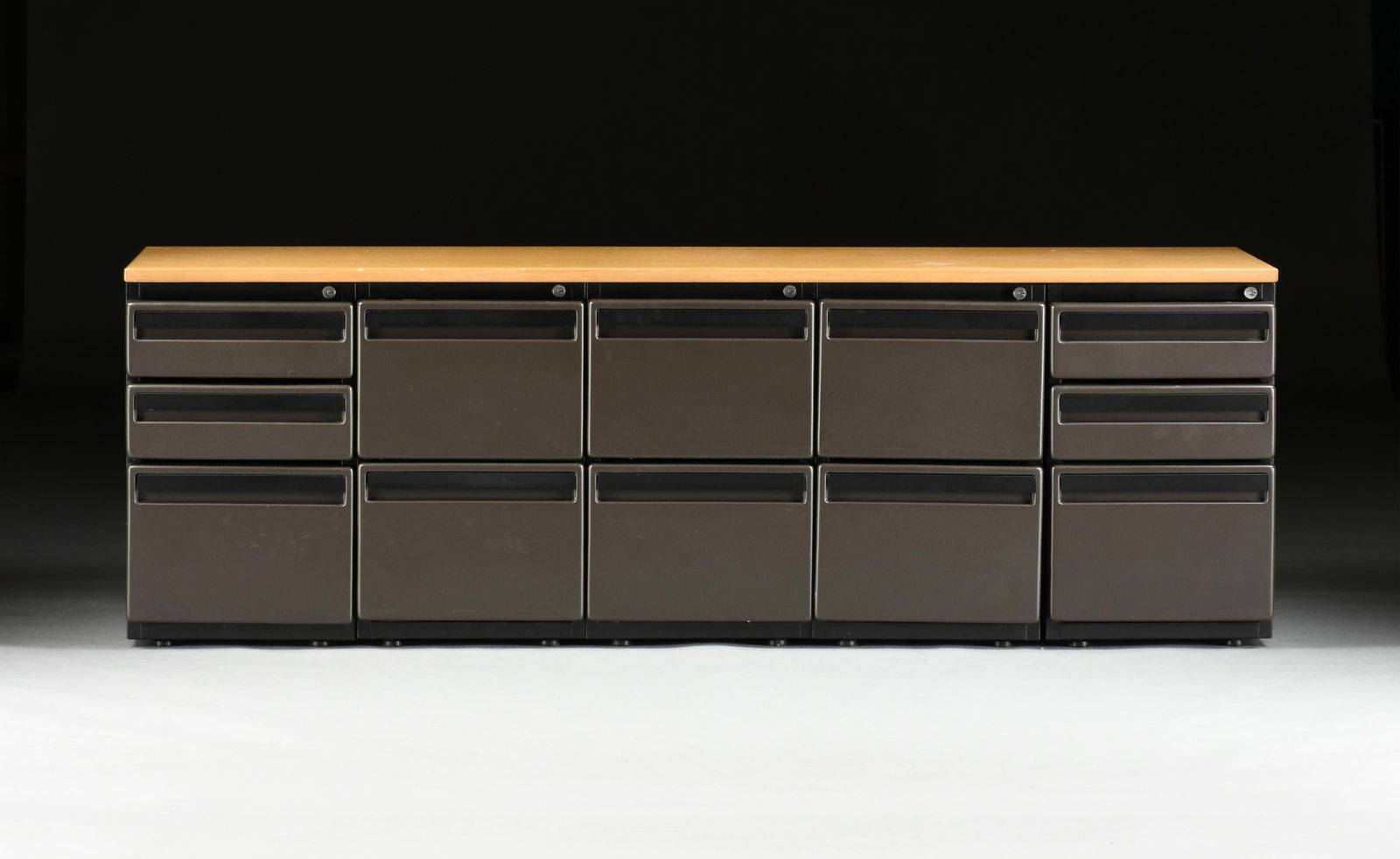 A BRUCE HANNAH FOR KNOLL ASSOCIATES OFFICE CREDENZA, 1981: A BRUCE HANNAH FOR KNOLL ASSOCIATES OFFICE CREDENZA, 1981, with an oak top over a modular plastic base with drawers, with original Knoll label. Height: 27" Width: 80 1/4" Depth: 23 1/4" Provenance: Es