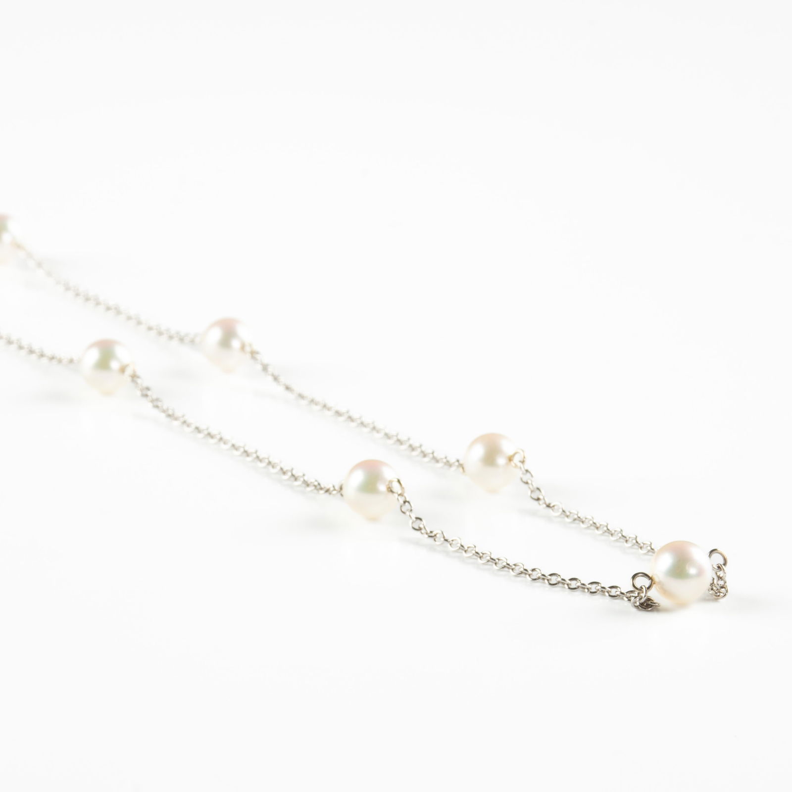 A MIKIMOTO 18K WHITE GOLD AND PEARL "Station" NECKLACE, JAPANESE, 21ST CENTURY, fifteen 6.5 mm Akoya: A MIKIMOTO 18K WHITE GOLD AND PEARL "Station" NECKLACE, JAPANESE, 21ST CENTURY, fifteen 6.5 mm Akoya cultured pearls strung on an 18K white gold chain, stamped with maker's mark and "750," in the orig