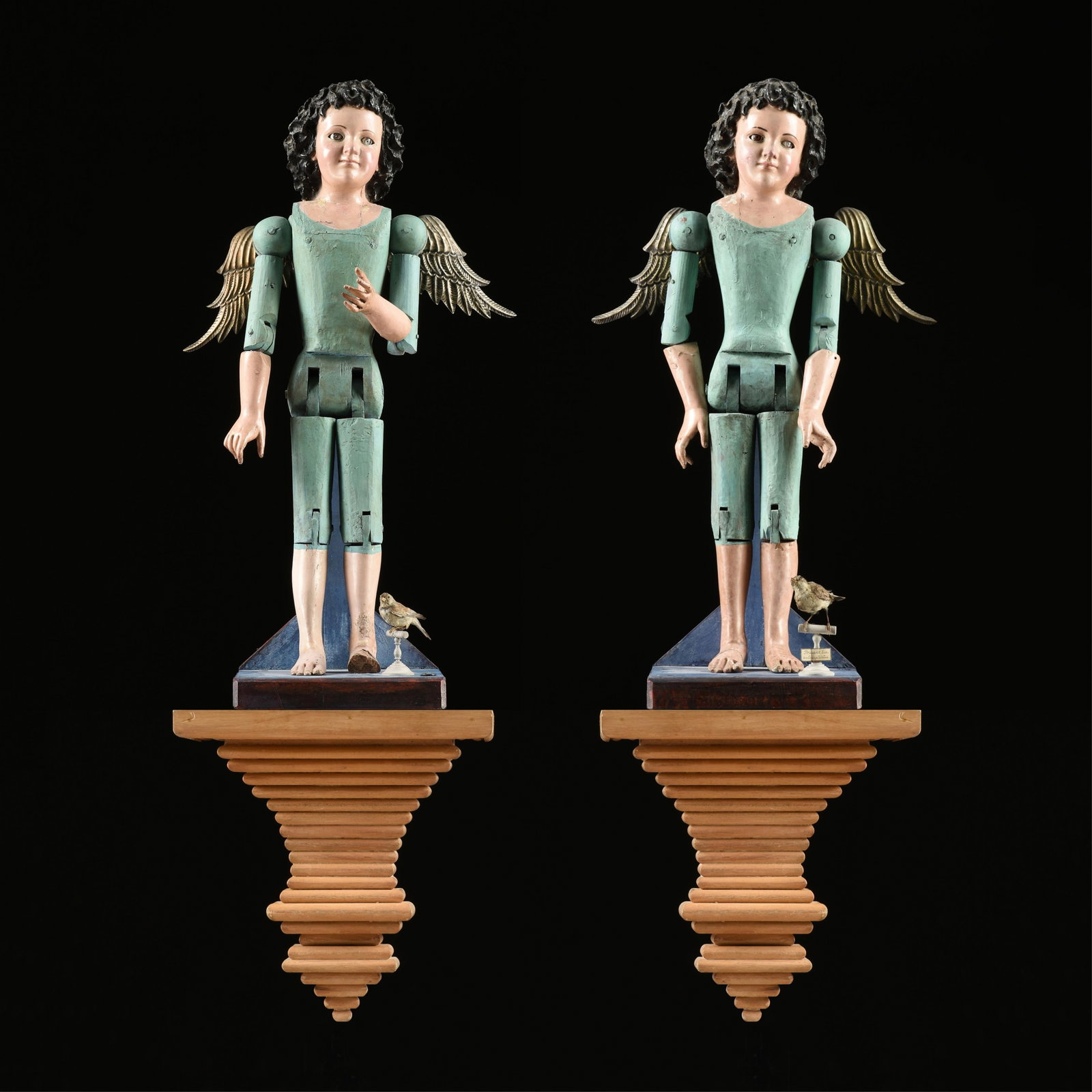 A PAIR OF WOODEN ANGELS, GUATEMALAN, CIRCA 1920s,: A PAIR OF WOODEN ANGELS, GUATEMALAN, CIRCA 1920s, wood, mixed media, gesso pigment, and silver; together with a pair of taxidermy birds and a pair of wooden wall sconces. 36 1/2 x 12 x 12 1/2 in. (92.