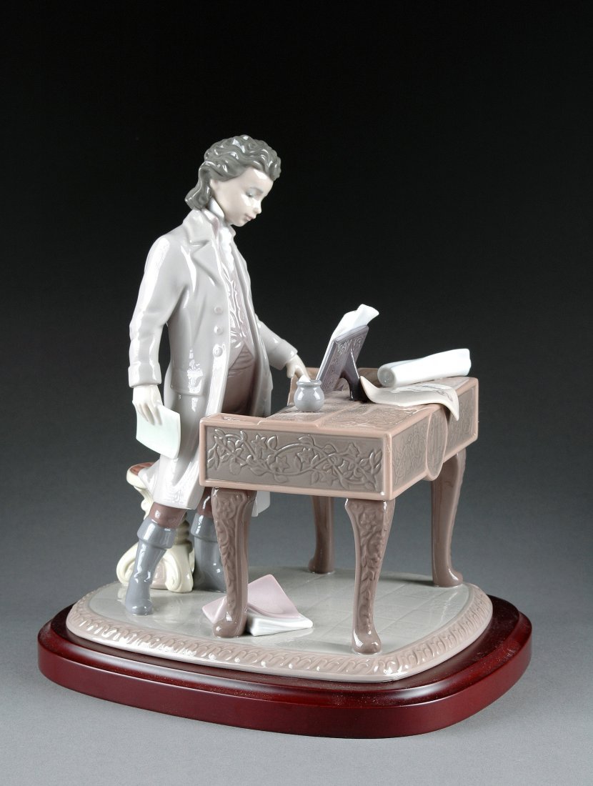 A LLADRO PORCELAIN FIGURAL SCULPTURE OF A YOUNG BE: A LLADRO PORCELAIN FIGURAL SCULPTURE OF A YOUNG BEETHOVEN, 1996, modeled standing wearing period costume and composing three sonatas on a harpsichord, raised on cabriole legs and a triangular tiled fl