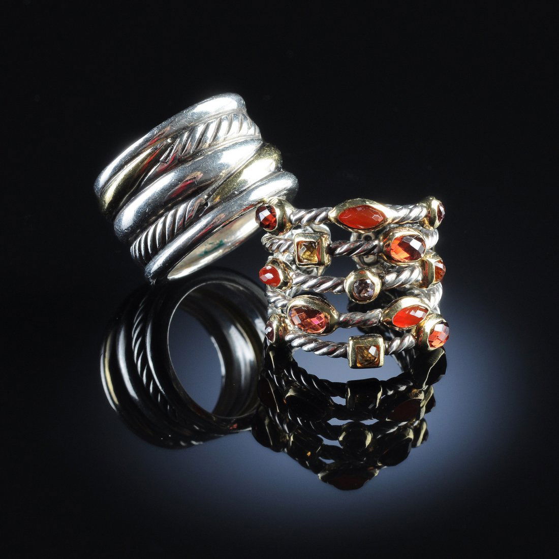 TWO 18K/STERLING DAVID YURMAN LADY'S RINGS. One t: TWO 18K/STERLING DAVID YURMAN LADY'S RINGS. One two-tone ring is a 13.5 millimeter crossover style ring, Size 5 3/4; the other ring is a "confetti ring" set with 13 miscellaneous color gemstones. Size