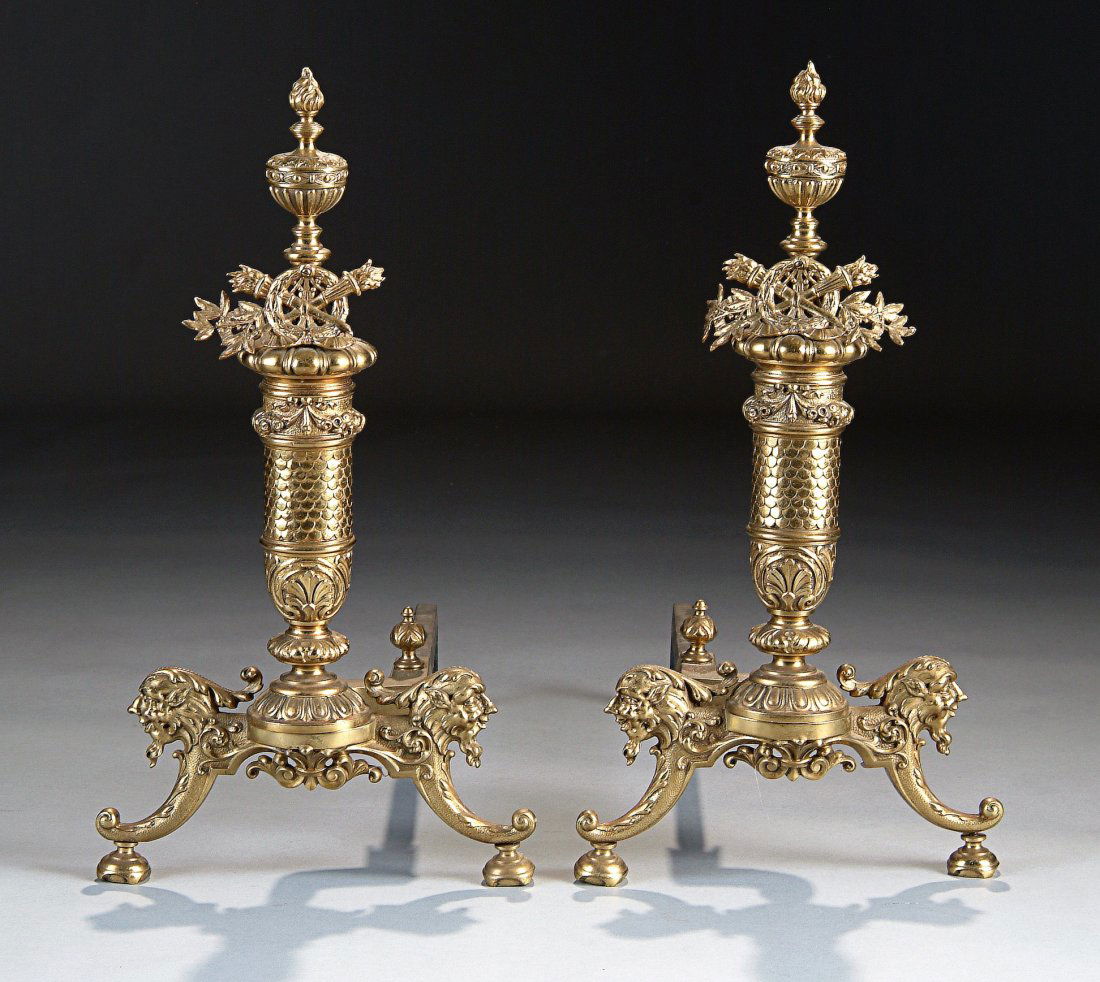 A PAIR OF BAROQUE STYLE GILT BRASS ANDIRONS, PROB: A PAIR OF BAROQUE STYLE GILT BRASS ANDIRONS, PROBABLY ENGLISH, LATE 19TH/EARLY 20TH CENTURY, each having a fishscale patterned columnar stem beneath a band of ribbon-tied floral swags surmounted by a