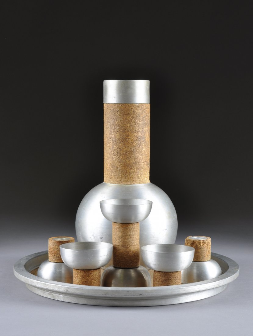 A RARE RUSSEL WRIGHT COCKTAIL SET, MODEL 326, CIR: A RARE RUSSEL WRIGHT COCKTAIL SET, MODEL 326, CIRCA 1930, of spun aluminum and cork comprising a decanter with strainer and lid, six cups and a tray, each signed with impressed manufacturer's mark. He