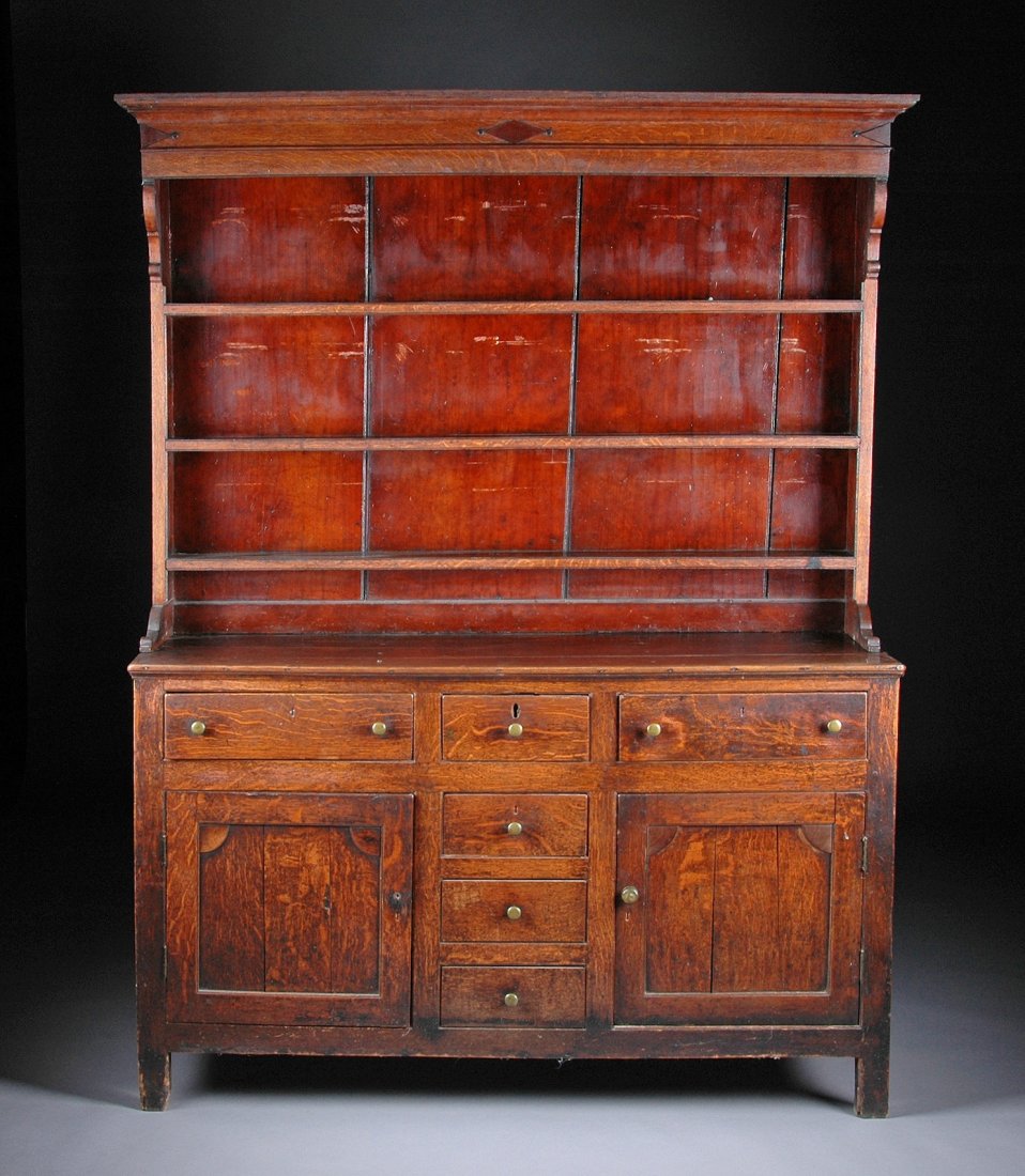 AN ANTIQUE PROVINCIAL CARVED OAK HUTCH, POSSIBLY : AN ANTIQUE PROVINCIAL CARVED OAK HUTCH, POSSIBLY ENGLAND OR IRELAND, 18TH/19TH CENTURY, the molded cornice above a flat frieze centering a lozenge and ball pendant flanked by similar decoration above 