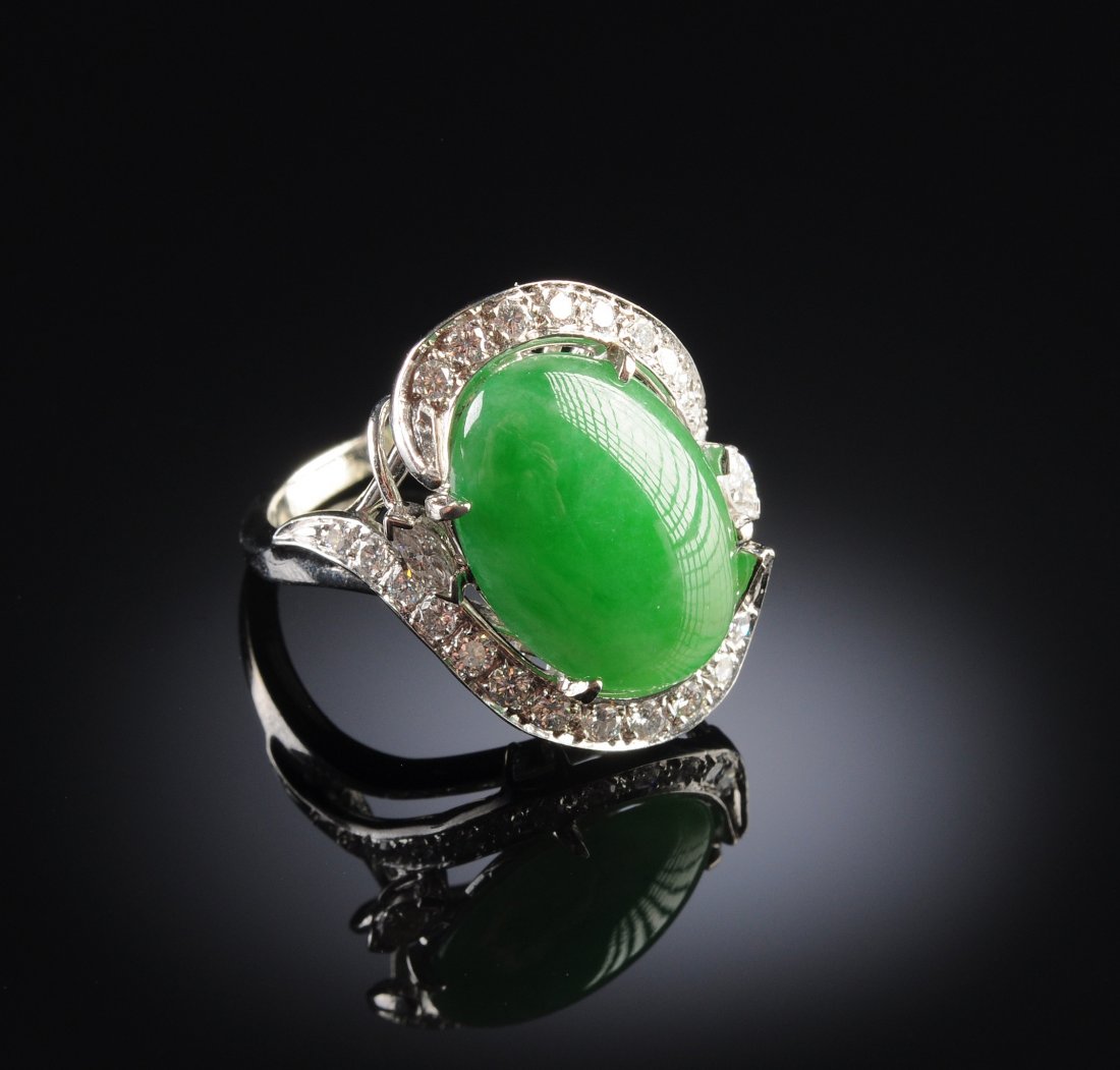 A 14K CHINESE "A" JADEITE JADE DIAMOND LADY'S RIN: A 14K CHINESE "A" JADEITE JADE DIAMOND LADY'S RING in white gold centering a natural, type "A" jadeite jade oval cabochon measuring approximately 11.2 x 17.2 x 4.7 millimeters, a medium apple green co