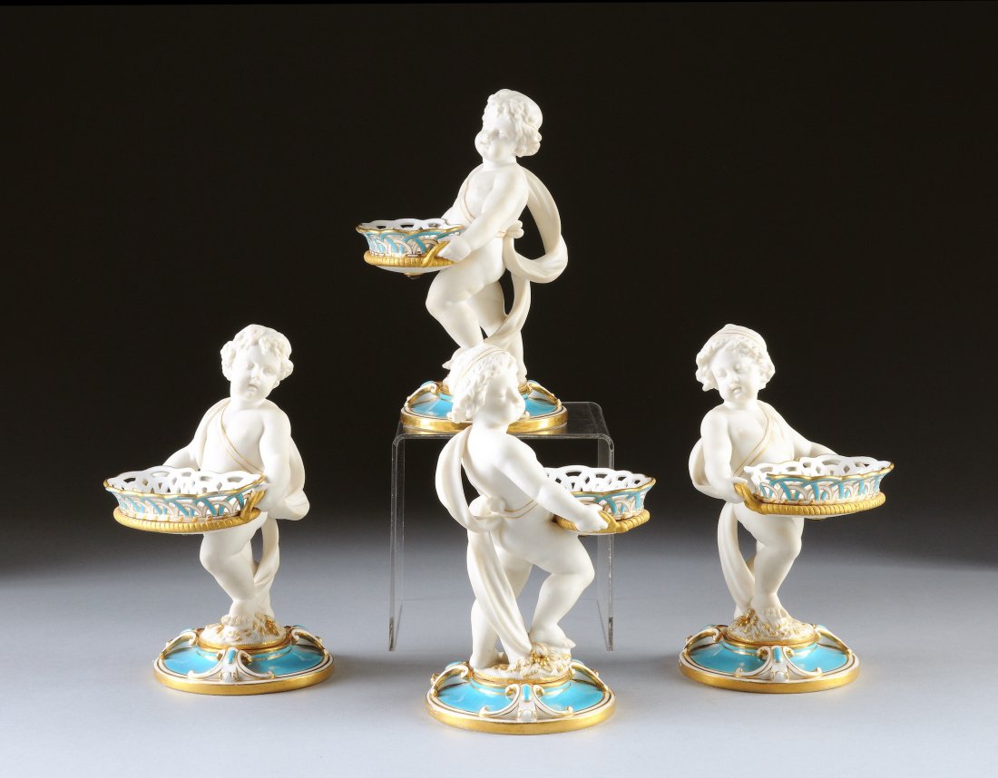 A SET OF FOUR MINTON STYLE TURQUOISE GROUND AND B: A SET OF FOUR MINTON STYLE TURQUOISE GROUND AND BISCUIT FIGURAL CONDIMENT BASKETS, LATE 19TH/EARLY 20TH CENTURY, each modeled as a standing putto wearing a billowing robe while carrying a reticulated 