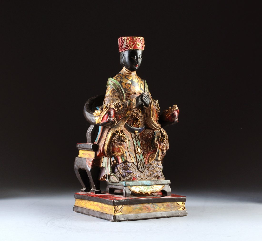 A SINO-TIBETAN PARCEL GILT AND POLYCHROME PAINTED: A SINO-TIBETAN PARCEL GILT AND POLYCHROME PAINTED CARVED WOOD FIGURE OF A MAIDEN DEITY, 20TH CENTURY, the ebonized face and hands with downcast eyes and serene expression beneath a flat circular cap e