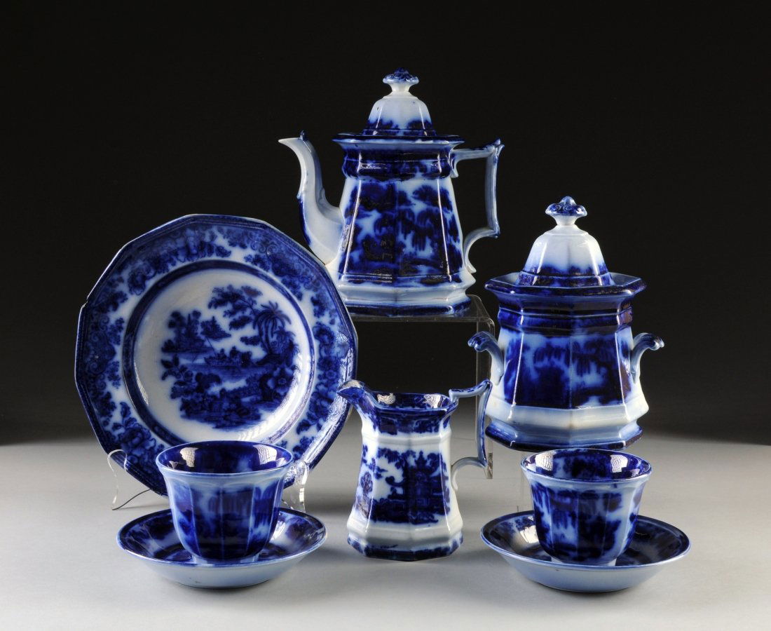 A FLOW BLUE AND WHITE IRONSTONE GROUPED TEA SERVICE, EN: A FLOW BLUE AND WHITE IRONSTONE GROUPED TEA SERVICE, ENGLISH, 19TH CENTURY, comprised of a "JH" soup bowl in the "Tonquin" pattern depicting two fishermen on an Asian pond, diameter: 9 1/2"; two condi