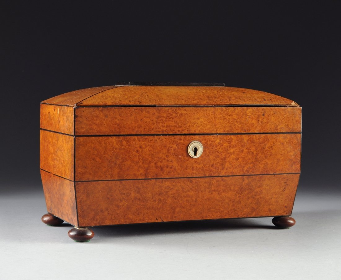 A WILLIAM IV BURL WALNUT AND EBONY TEA CADDY, of sarcop: A WILLIAM IV BURL WALNUT AND EBONY TEA CADDY, of sarcophagus form, the rectangular sloped angled top over a conforming panel, opening to a burl walnut lined interior with two tea compartments centerin