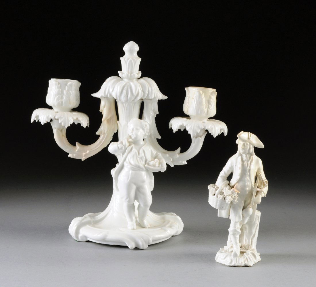 TWO DRESDEN BLANC DE CHINE PORCELAIN PIECES, 20TH CENTU: TWO DRESDEN BLANC DE CHINE PORCELAIN PIECES, 20TH CENTURY, comprised of a two light candelabra with standing figure of a boy, blue two crossed swords mark, height: 9"; a standing figure of a man carry
