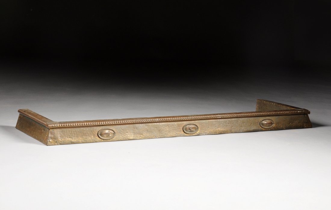 AN AMERICAN ARTS AND CRAFTS PERIOD FIREPLACE FENDER, LA: AN AMERICAN ARTS AND CRAFTS PERIOD FIREPLACE FENDER, LATE 19TH CENTURY/EARLY 20TH CENTURY, the gilded copper sheet hammered with beading to edge of bevel, applied oval medallions with beaded trim, the