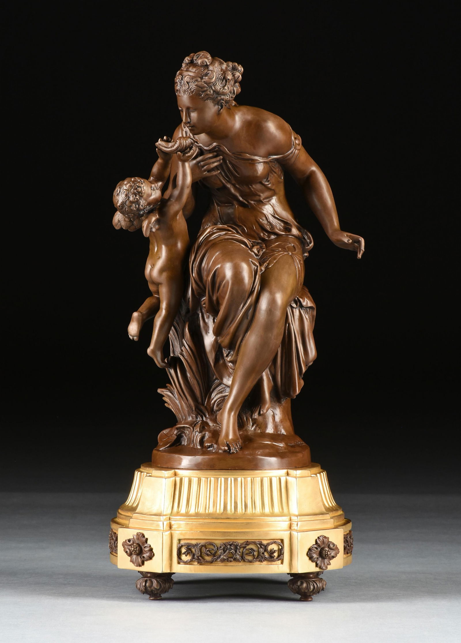 after MATHURIN MOREAU "Venus and Cupid," 20TH CENTURY,: after MATHURIN MOREAU "Venus and Cupid," 20TH CENTURY,bronze with gilt bronze base, inscribed at base, "Mth Moreau."27 1/2 in. (69.9 cm.), Diameter: 13 in. (33 cm.) Provenance: Private Collection, Hou