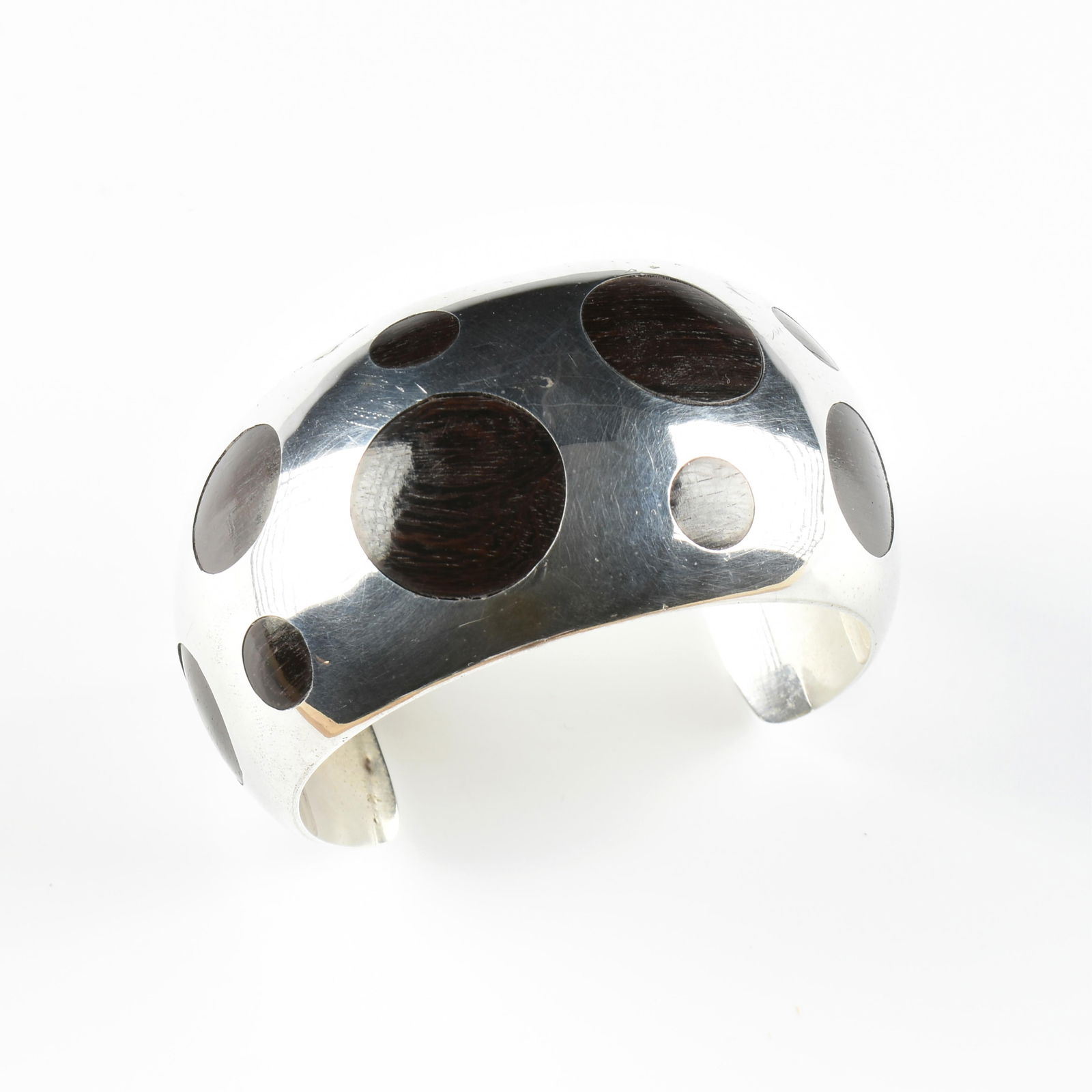 WILLIAM SPRATLING (American 1900-1967) A TAXCO STERLING SILVER AND EBONY BRACELET, LATE 20TH: WILLIAM SPRATLING (American 1900-1967) A TAXCO STERLING SILVER AND EBONY BRACELET, LATE 20TH CENTURY,a sterling silver cuff bracelet with fourteen inlaid ebony circles, marked inside, "William Spratli