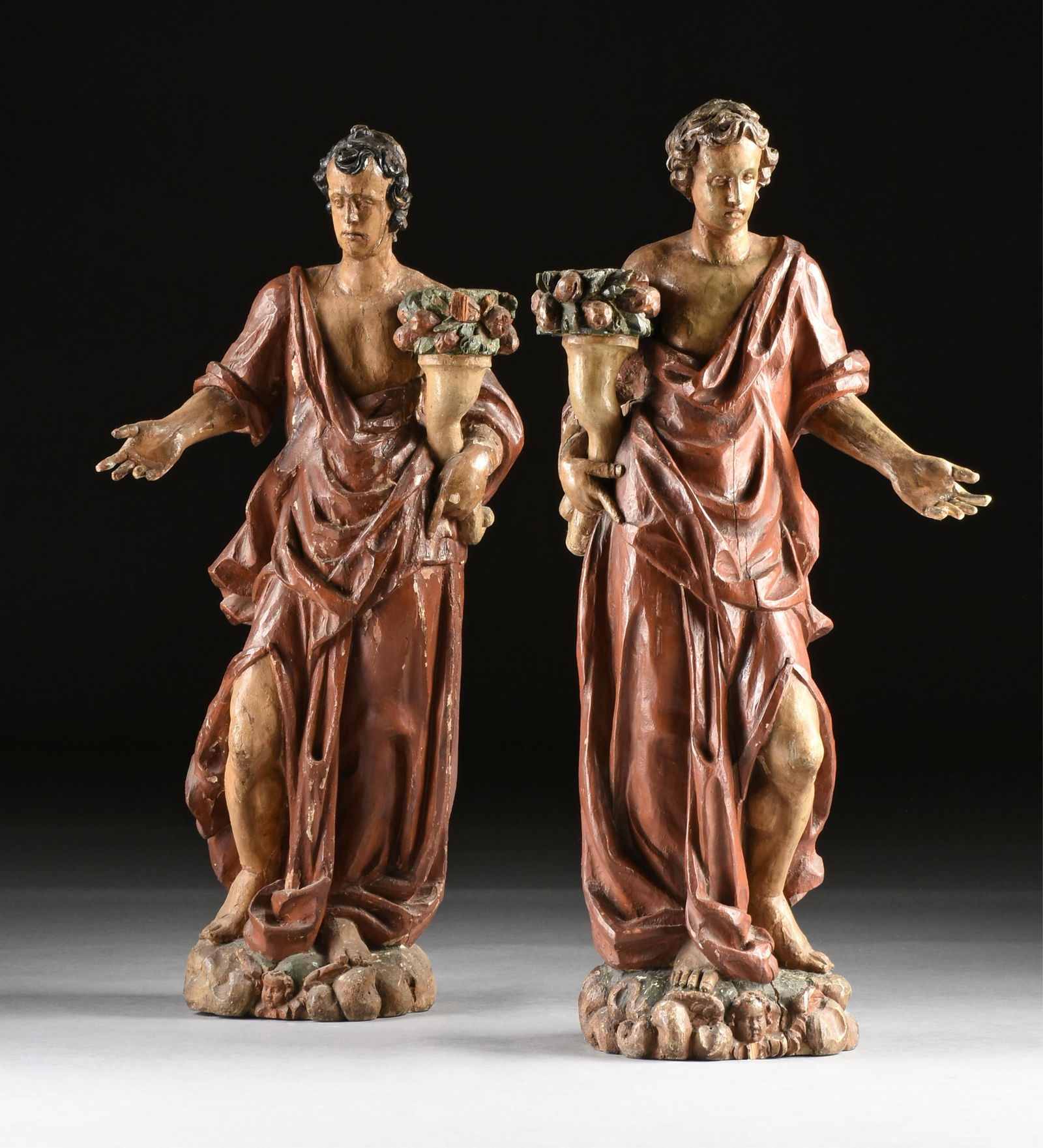 A LARGE PAIR OF FIGURAL TORCHERES, POSSIBLY ITALIAN, 19TH/20TH CENTURY,: A LARGE PAIR OF FIGURAL TORCHERES, POSSIBLY ITALIAN, 19TH/20TH CENTURY,hand carved, painted, and parcel gilt wooden torcheres, probably depicting Christian saints, each holding a base for a candle.Eac