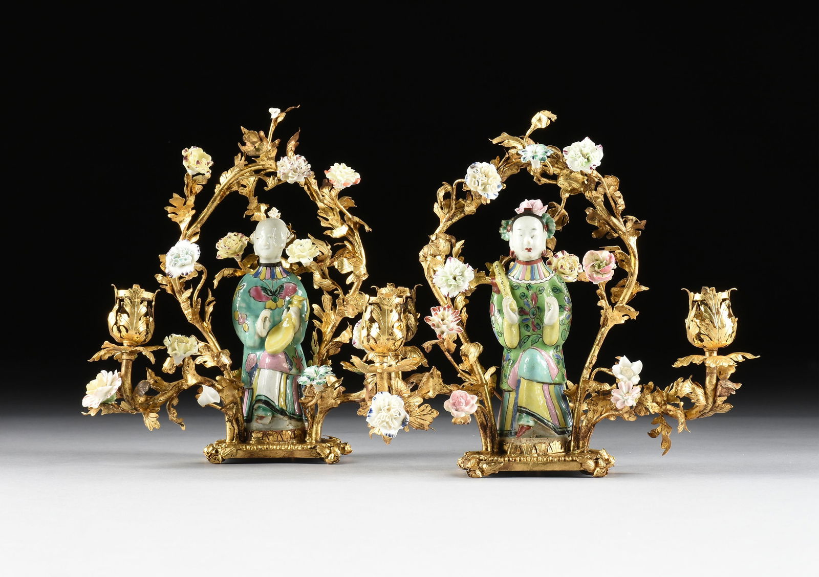 A PAIR OF ROCOCO STYLE GILT METAL AND PORCELAIN TWO-LIGHT CANDELABRA, FRENCH OR GERMAN, LATE 19TH: A PAIR OF ROCOCO STYLE GILT METAL AND PORCELAIN TWO-LIGHT CANDELABRA, FRENCH OR GERMAN, LATE 19TH CENTURY,two gilt metal candelabra with hand painted porcelain flowers and with porcelain figures of Ch