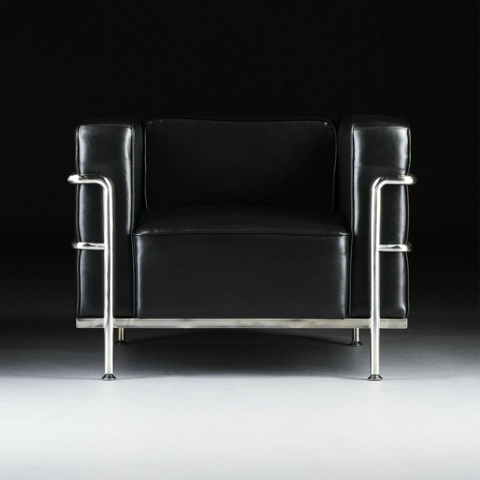 A PAIR OF MID CENTURY MODERN STYLE ARMCHAIRS AND OTTOMAN, 20TH CENTURY,: A PAIR OF MID CENTURY MODERN STYLE ARMCHAIRS AND OTTOMAN, 20TH CENTURY,black faux leather upholstery with matching pipe trim apparently influenced by French furniture designers Le Corbusier, Pierre Je