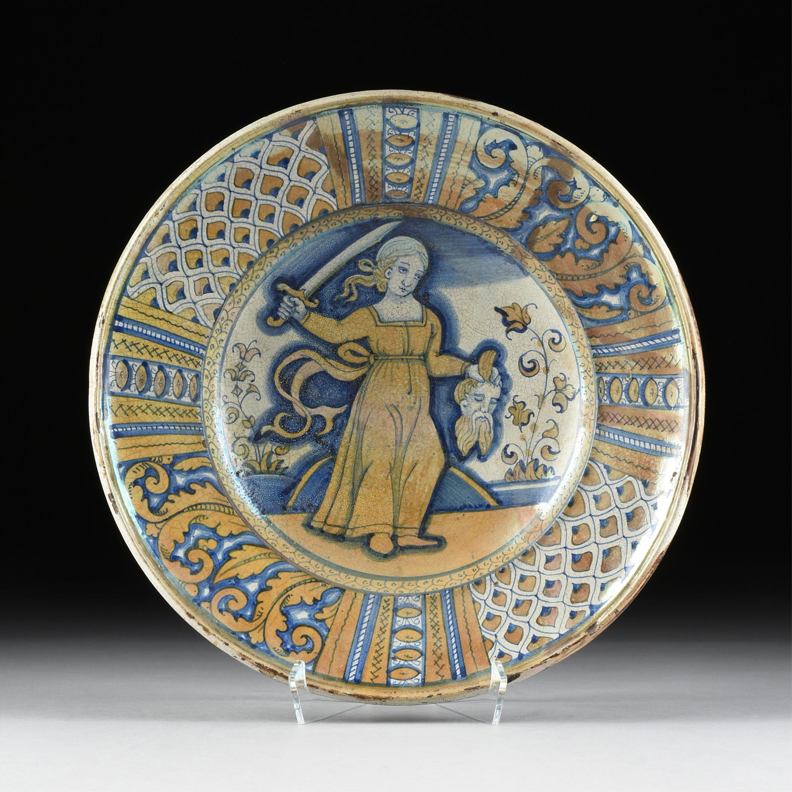 A DERUTA MAIOLICA GOLD-LUSTERED CHARGER, ITALIAN, CIRCA 1530,: A DERUTA MAIOLICA GOLD-LUSTERED CHARGER, ITALIAN, CIRCA 1530,hand painted ceramic with a central scene depicting Judith with the decapitated head of Holofernes, surrounded by bands of foliate scroll a
