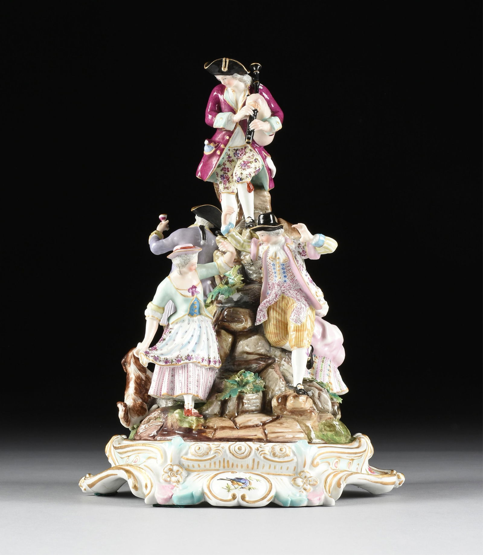 A ROCOCO STYLE PORCELAIN FIGURAL GROUP OF REVELERS, POSSIBLY GERMAN, 19TH/20TH CENTURY,: A ROCOCO STYLE PORCELAIN FIGURAL GROUP OF REVELERS, POSSIBLY GERMAN, 19TH/20TH CENTURY,a hand painted porcelain centerpiece in the style of Meissen, with spurious signature on the underside.13 x 8 1/2