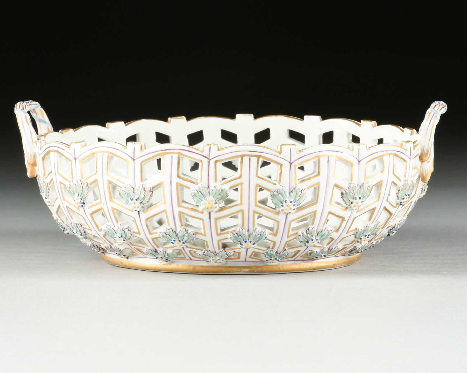 A PORCELAIN FRUIT BASKET, PROBABLY ENGLISH, 20TH CENTURY,: A PORCELAIN FRUIT BASKET, PROBABLY ENGLISH, 20TH CENTURY,hand painted porcelain lattice basket decorated with birds and berries, and with a spurious mark on the underside.3 3/4 x 10 1/4 x 8 3/4 in. (9