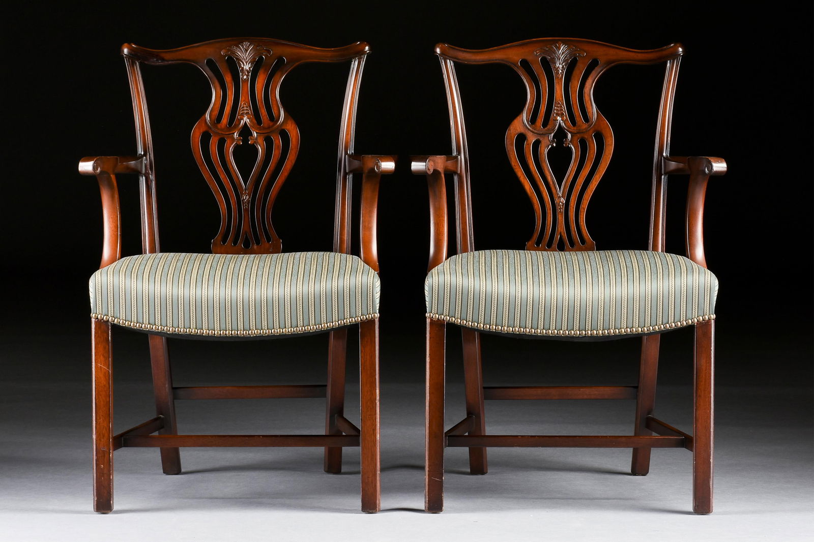 A PAIR OF CHIPPENDALE STYLE ARM CHAIRS, 20TH CENTURY,: A PAIR OF CHIPPENDALE STYLE ARM CHAIRS, 20TH CENTURY,two mahogany chairs with striped upholstery.Each: 37 x 26 x 21 in. (94 x 66 x 53.3 cm.) Provenance: Collection of Paul Doyle, Houston, Texas.
