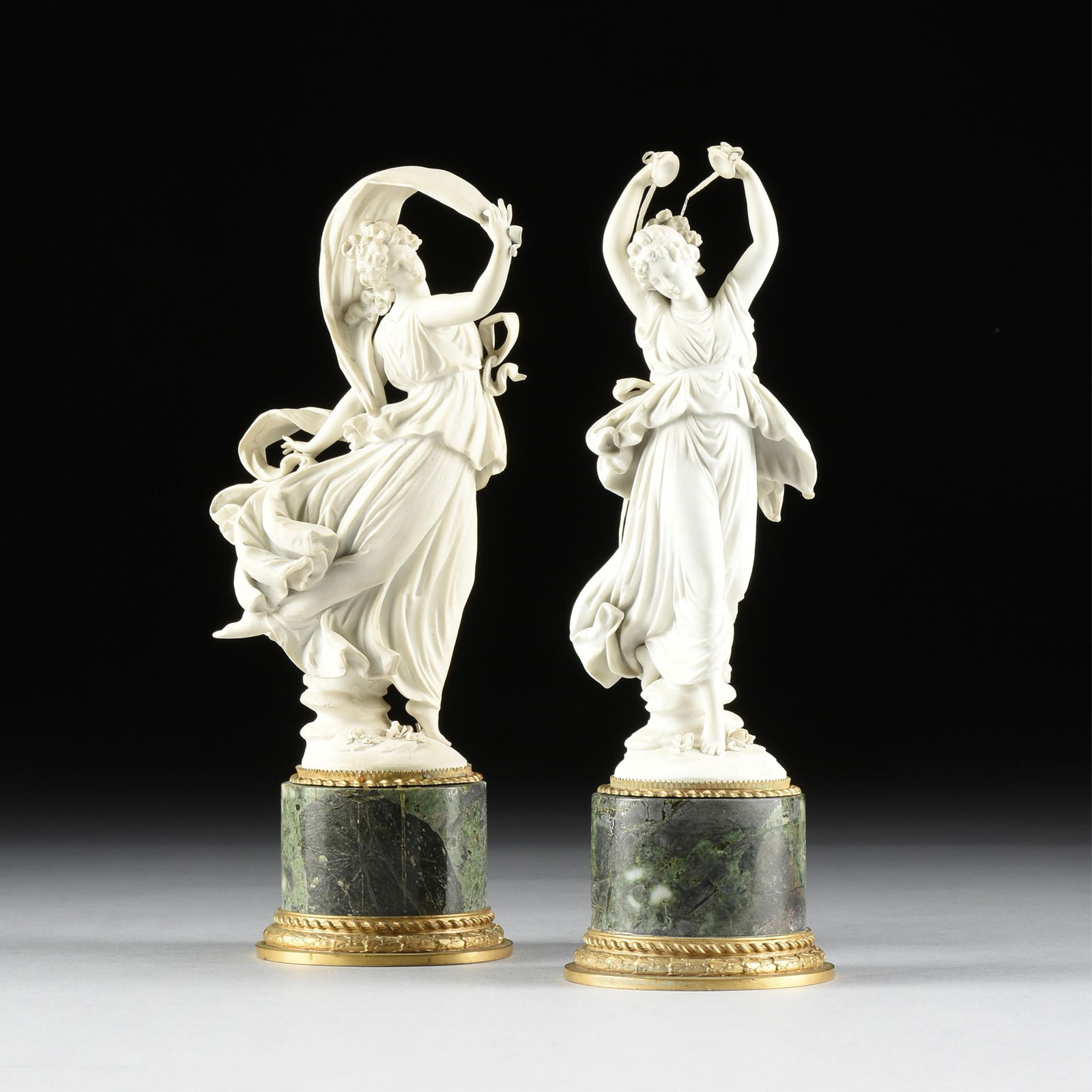 A PAIR OF VOLKSTEDT BISCUIT PORCELAIN DANCERS, GERMAN, 19TH/20TH CENTURY,: A PAIR OF VOLKSTEDT BISCUIT PORCELAIN DANCERS, GERMAN, 19TH/20TH CENTURY,two biscuit porcelain statuettes of dancing female figures in classical dress, each mounted on a marble base with gilt bronze m
