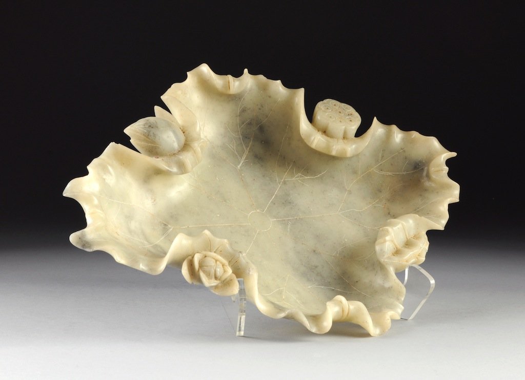 A LARGE VINTAGE CHINESE CARVED SOAPSTONE LOTUS LEAF BRU: A LARGE VINTAGE CHINESE CARVED SOAPSTONE LOTUS LEAF BRUSHWASHER DISH, FIRST-HALF 20TH CENTURY, of naturalistic form with curled rim revealing a lotus pod, bud, and blossom enclosing incised details on