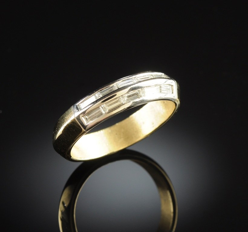 A 14K GOLD AND DIAMOND MAN'S WEDDING RING in two tone: A 14K GOLD AND DIAMOND MAN'S WEDDING RING, in two tone set with ten baguette cut diamonds with an approximate weight of 1.00 Cts., Color Grade - G, Clarity Grade - VS1. Weight 7.6 grams. Size 10 1/2.