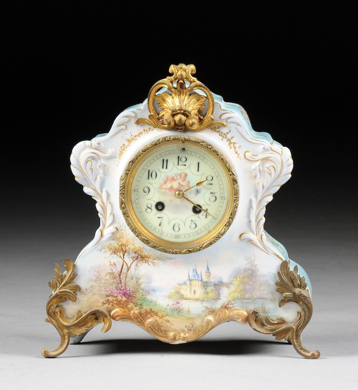 A BELLE ÉPOQUE ORMOLU MOUNTED SKY BLUE GROUND PORCELAIN: A BELLE ÉPOQUE ORMOLU MOUNTED SKY BLUE GROUND PORCELAIN MANTLE CLOCK, MECHANISM BY AD MOUGIN, CIRCA 1890, in the Rococo Revival style with a shaped triangular case having a reticulated "C" scroll and