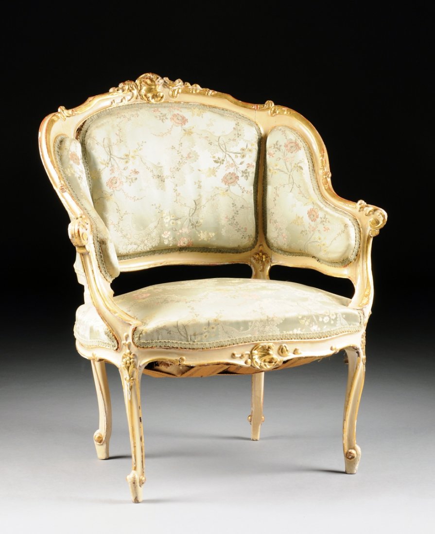 A ROCOCO REVIVAL PARCEL GILT AND WHITE PAINTED BERGÈRE,: A ROCOCO REVIVAL PARCEL GILT AND WHITE PAINTED BERGÈRE, CIRCA 1880, the shaped serpentine crest rail centering a "C" shell and scrolling foliage pendant continuing to similarly detailed curled arms a