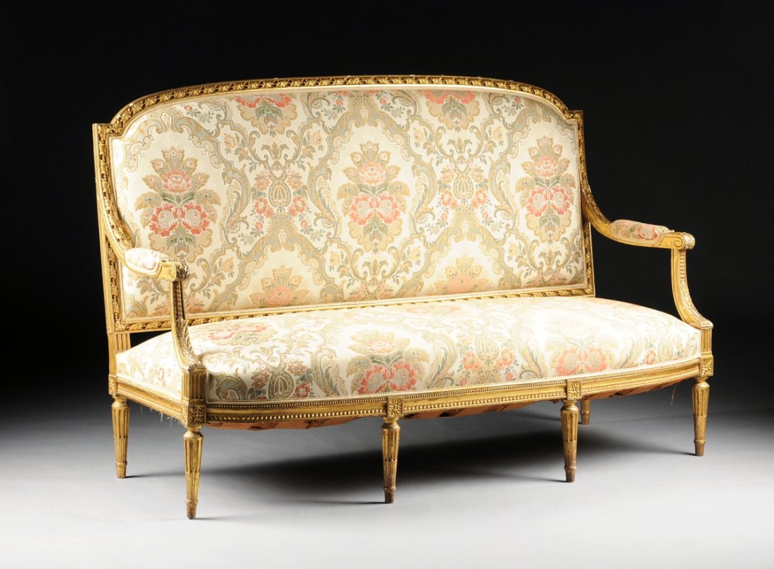 A LARGE LOUIS XVI STYLE PARCEL GILT CARVED WOOD SETTEE,: A LARGE LOUIS XVI STYLE PARCEL GILT CARVED WOOD SETTEE, LATE 19TH CENTURY, finely detailed with an arched rectangular padded back centering a beaded rolling acanthus crest rail continuing to scrolled 