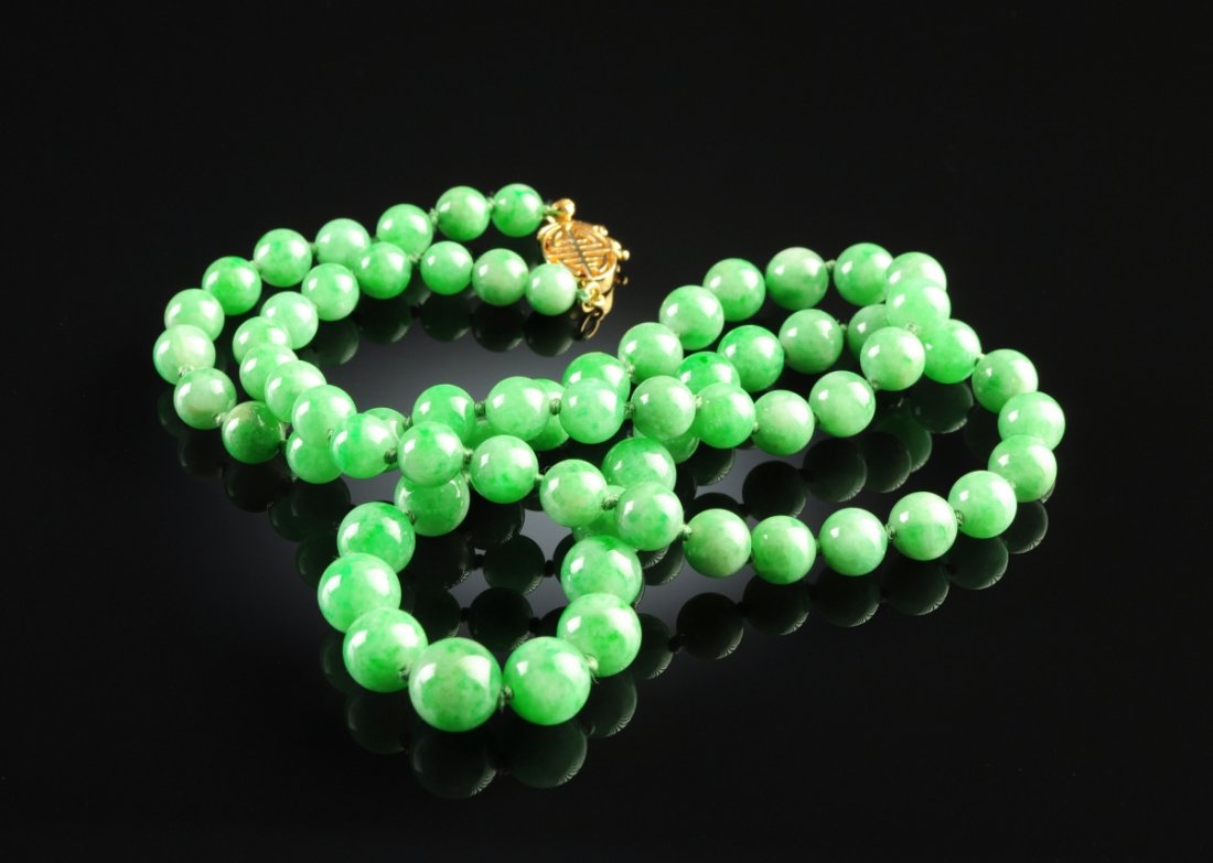 A STRAND OF GREEN CHINESE "A" JADEITE JADE LADY'S BEADS: A STRAND OF GREEN CHINESE "A" JADEITE JADE LADY'S BEADS, with an 18K yellow gold clasp, 22" in length, consisting of 69 natural, type "A" jadeite jade spherical beads graduated in size, measuring from