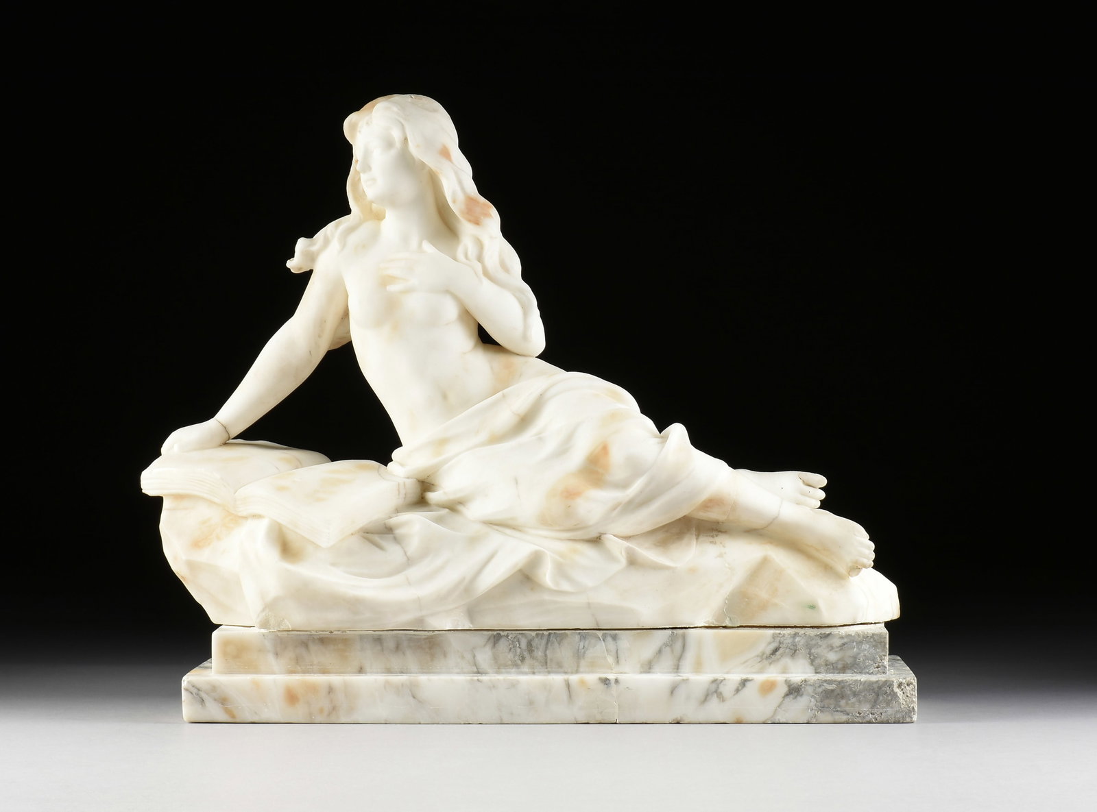 ITALIAN SCHOOL, Reclining Nude with Book (Untitled), 19TH/20TH CENTURY,: ITALIAN SCHOOL, Reclining Nude with Book (Untitled), 19TH/20TH CENTURY, a carved marble sculpture of a young woman leaning on a book and the lower half of her body covered in drapery. 20 x 24 x 9 in.