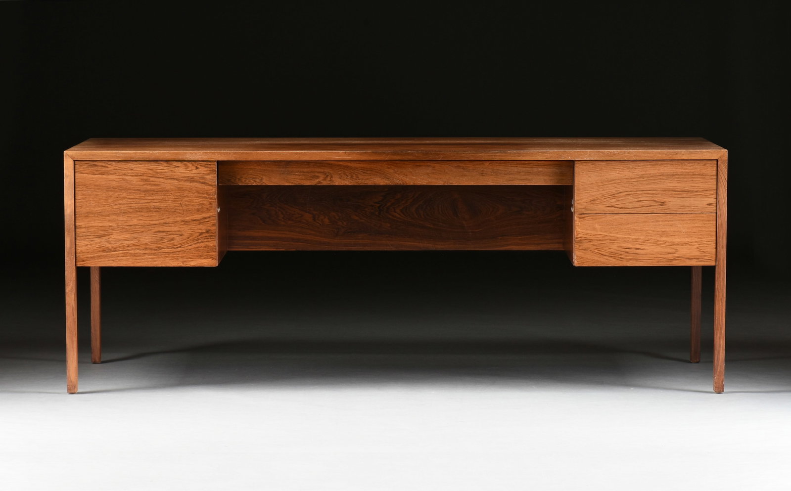 A HARVEY PROBBER DESK, AMERICAN, CIRCA 1970,: A HARVEY PROBBER DESK, AMERICAN, CIRCA 1970, mid-century modern four drawer walnut desk with a filing drawer on the left, two smaller drawers on the right, and a long shallow center drawer, and with m