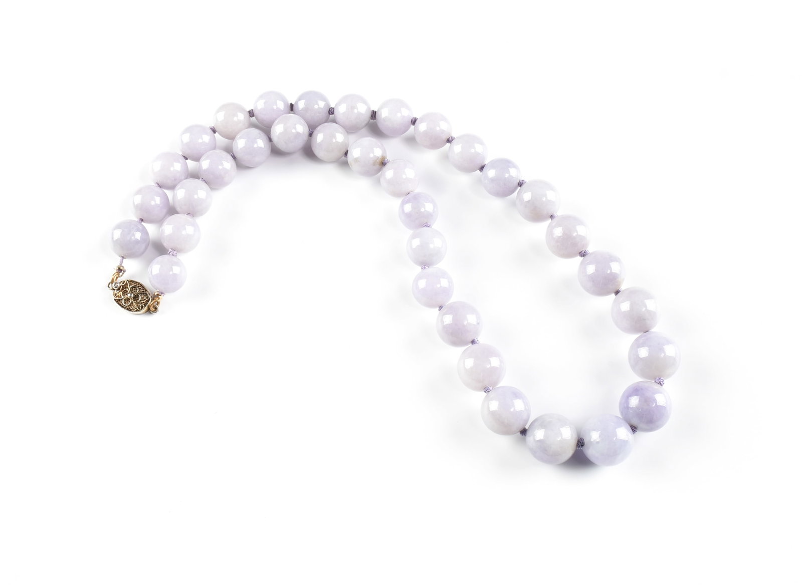 A LIGHT LAVENDER JADEITE BEADED NECKLACE,: A LIGHT LAVENDER JADEITE BEADED NECKLACE, thirty-five type A natural pale lavender round graduated jadeite beads (approx. 13.5-15.8 mm) strung on knotted silk with a silver box tab closure, marked, "s