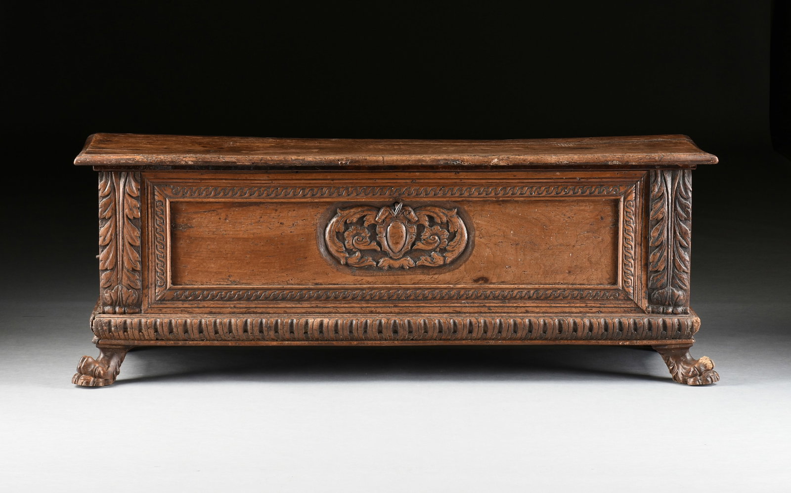 A BAROQUE CASSONE MARRIAGE CHEST, ITALIAN, 17TH/18TH CENTURY,: A BAROQUE CASSONE MARRIAGE CHEST, ITALIAN, 17TH/18TH CENTURY, carved walnut chest with paw feet and iron handles and working lock. 24 x 66 x 23 in. (61 x 167.6 x 58.4 cm.) Provenance: Private