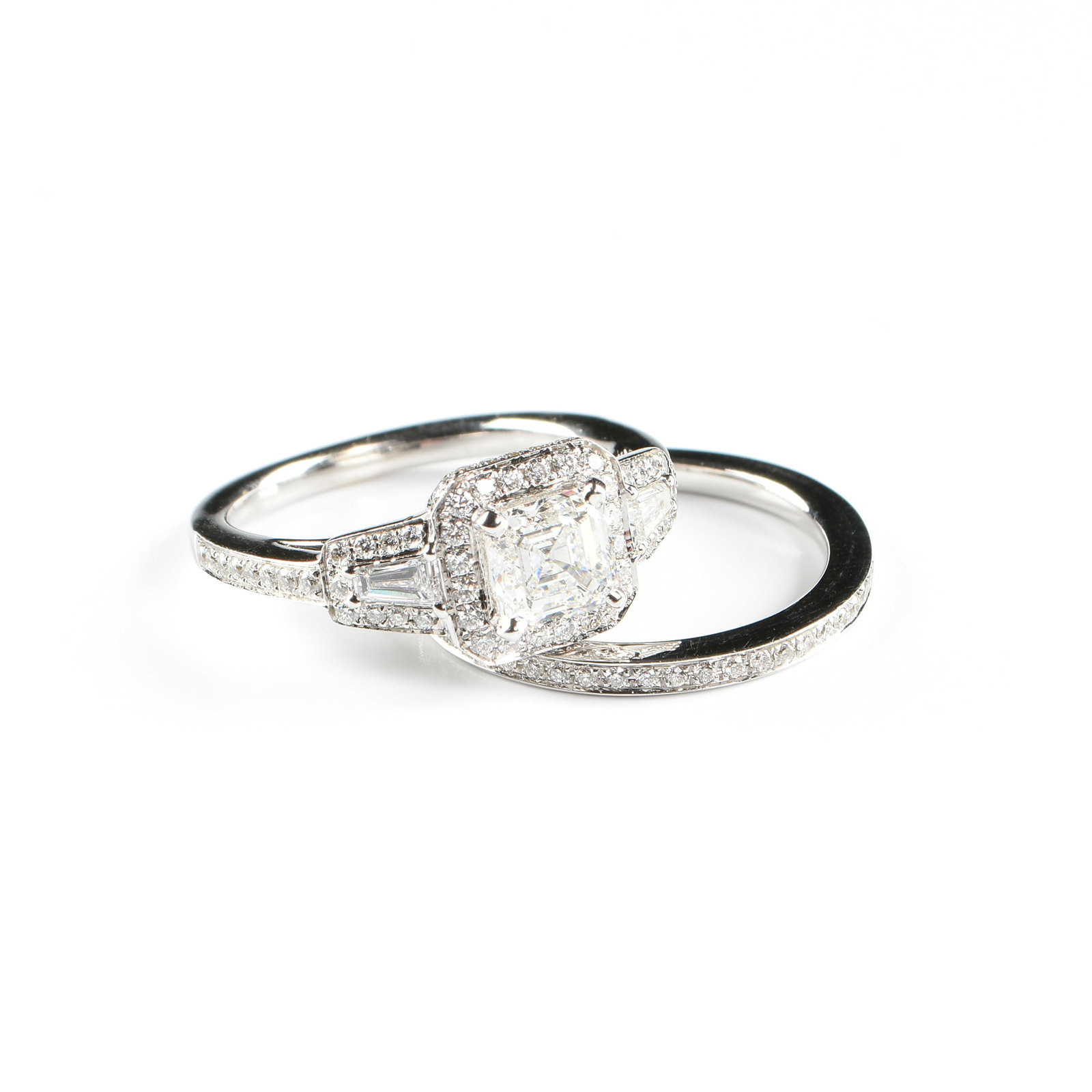 AN 18K GOLD TYCOON DIAMOND ENGAGEMENT RING AND WEDDING BAND SET,: AN 18K GOLD TYCOON DIAMOND ENGAGEMENT RING AND WEDDING BAND SET, 18k white gold rings, the engagement ring set with a 1.02 carat square emerald cut diamond (G, VS2) surrounded by a halo of round brill