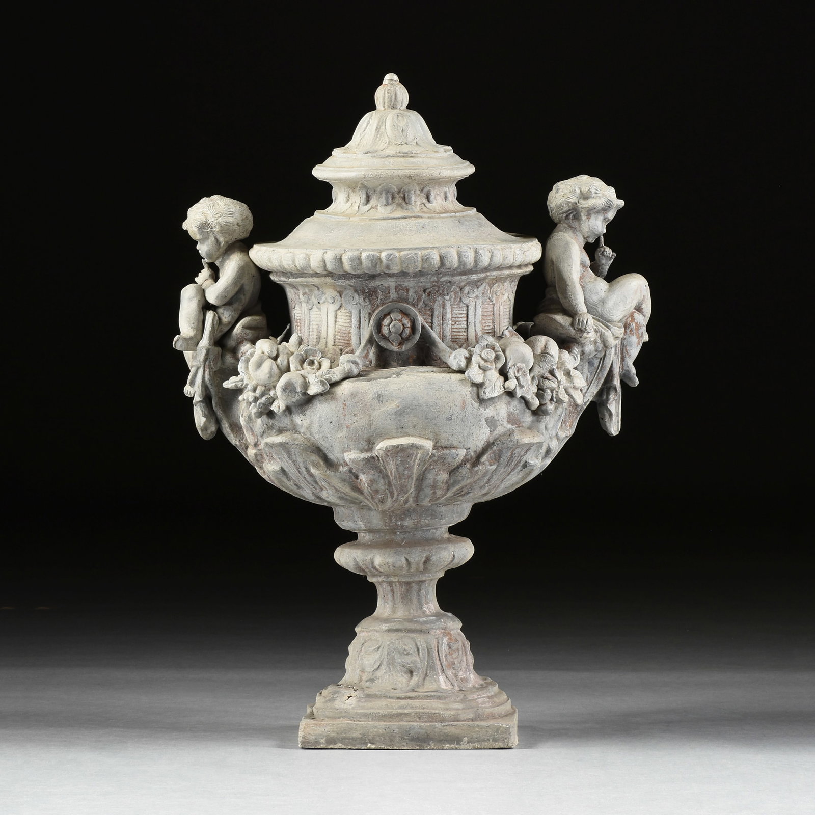 A ROCOCO STYLE GARDEN URN, ENGLISH OR FRENCH, 19TH CENTURY,: A ROCOCO STYLE GARDEN URN, ENGLISH OR FRENCH, 19TH CENTURY, cast lead lidded garden urn decorated with cherubs and and floral garlands. 36 x 30 x 20 in. (91.4 x 76.2 x 50.8 cm.) Provenance: Collection