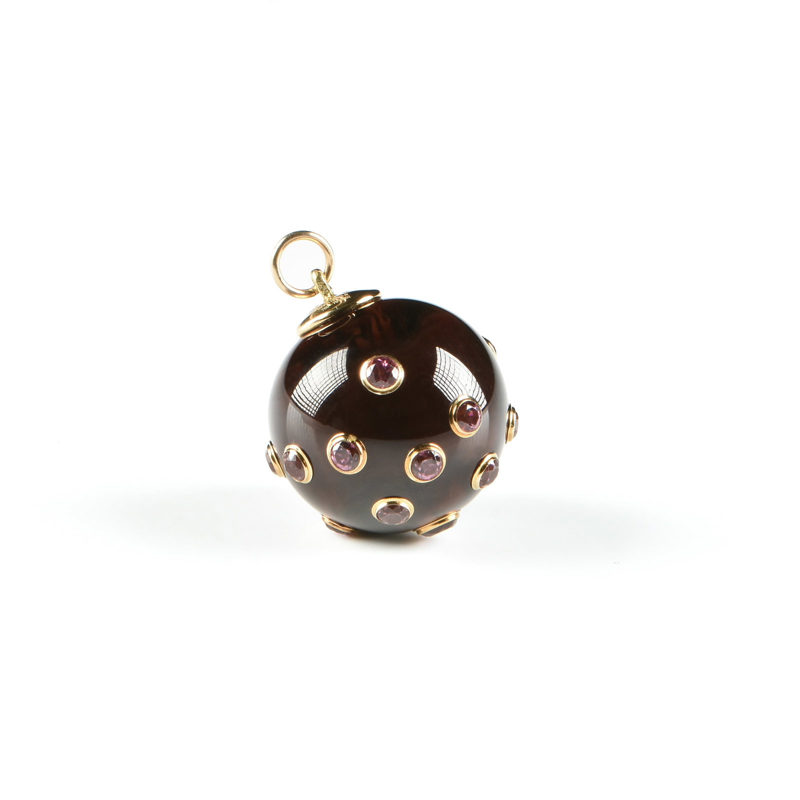 A MARK DAVIS 18K GOLD, BAKELITE, PINK TOPAZ, AND RUBY PENDANT,: A MARK DAVIS 18K GOLD, BAKELITE, PINK TOPAZ, AND RUBY PENDANT, a dark reddish/black bakelite sphere with 18k yellow gold mounts and set with fourteen pink topaz (3 mm) and one ruby (3.7 mm), marked