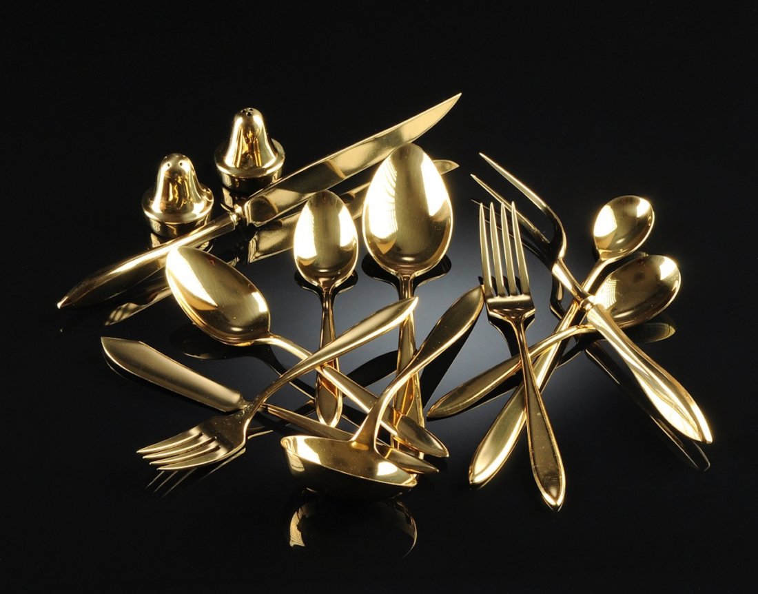 A DIRILYTE GOLD TONED FLATWARE SERVICE FOR EIGHT, 20TH: A DIRILYTE GOLD TONED FLATWARE SERVICE FOR EIGHT, 20TH CENTURY, comprising 8 knives, 4 serving spoons, 8 soup spoons, 16 table spoons, 8 salad forks, 8 dessert forks, 8 coffee spoons, 1 butter knife, 