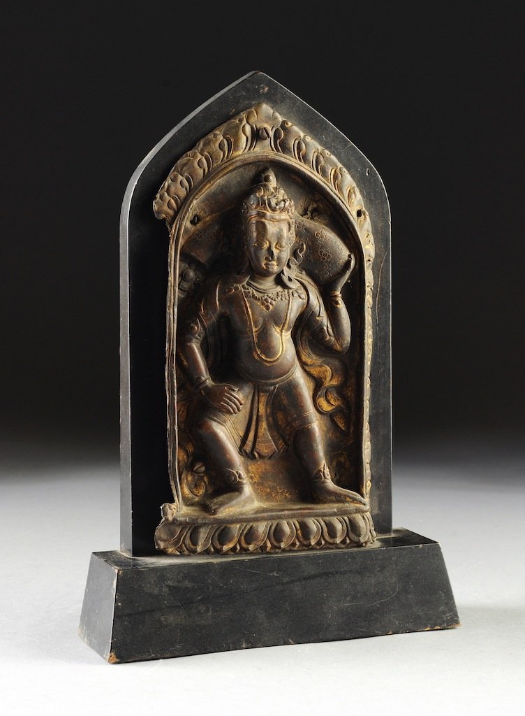 A TIBETAN PARCEL GILT REPOUSSÉ BRONZE ALTAR PLAQUE, 19T: A TIBETAN PARCEL GILT REPOUSSÉ BRONZE ALTAR PLAQUE, 19TH CENTURY, the standing deity with thick wavy hair above long eared lobes suspending discs and wearing a billowing shawl above a jeweled necklac