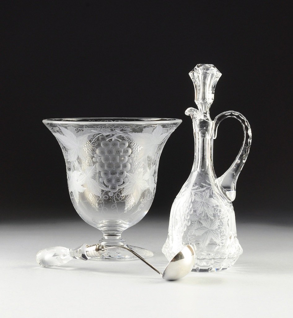A SET OF THREE AMERICAN CUT AND ETCHED GLASS WARES, ONE: A SET OF THREE AMERICAN CUT AND ETCHED GLASS WARES, ONE SIGNED PAIRPOINT, SECOND-QUARTER 20TH CENTURY, each with grape cluster-and-leaf decoration, comprising a silver plate mounted cut glass ladle wi