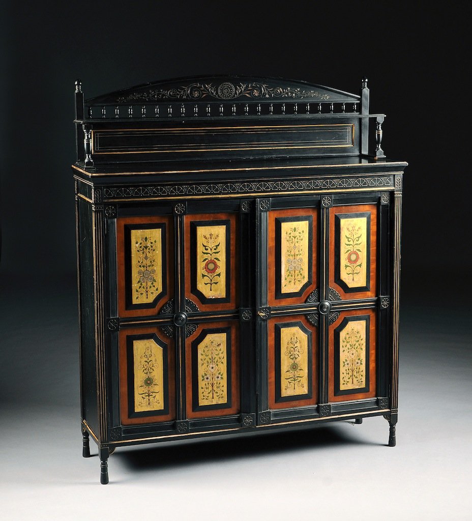 AN ENGLISH AESTHETIC MOVEMENT PARCEL GILT AND POLYCHROM: AN ENGLISH AESTHETIC MOVEMENT PARCEL GILT AND POLYCHROME PAINTED EBONIZED CABINET, BY WILLIAM WALKER & SONS, BUNHILL ROW, LONDON, CIRCA 1875, the arched cornice encloses incised scrolling floral vines