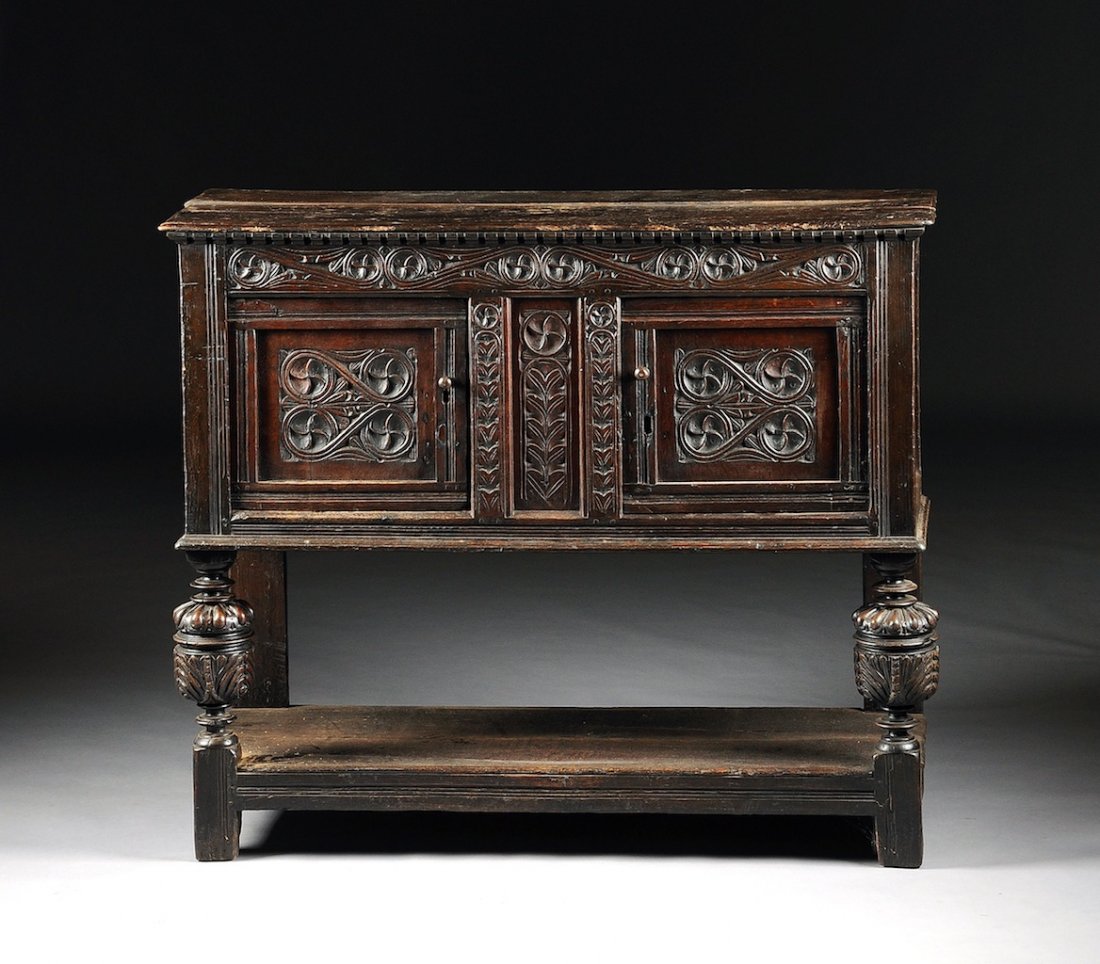 A CHARLES II CARVED WOOD SIDEBOARD, LATE 17TH CENTURY,: A CHARLES II CARVED WOOD SIDEBOARD, LATE 17TH CENTURY, the rectangular top above a frieze of "S" form detailed devices and two doors centering paired scrolling pendants, on acorn form legs with gadroo