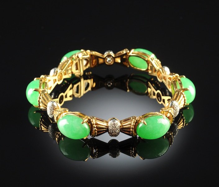 AN 18K YELLOW GOLD, CHINESE "A" JADEITE JADE, AND DIA: AN 18K YELLOW GOLD, CHINESE "A" JADEITE JADE, AND DIAMOND LADY'S BRACELET, the mounting set with a register of six natural type "A" jadeite jade oval stones measuring approximately 14.5 x 9.5 x 7.1 mi
