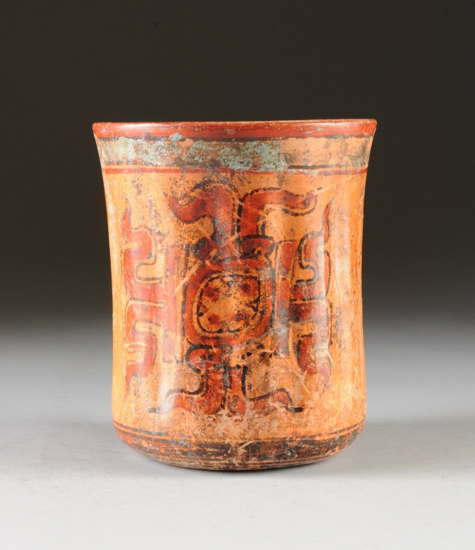 A MAYAN POLYCHROME PAINTED POTTERY VESSEL, LATE CLASSIC: A MAYAN POLYCHROME PAINTED POTTERY VESSEL, LATE CLASSIC PERIOD, CIRCA A.D. 550-950, of slightly waisted cylindrical form with remnants of a bright blue banded rim and base, enclosing fluted sides cent
