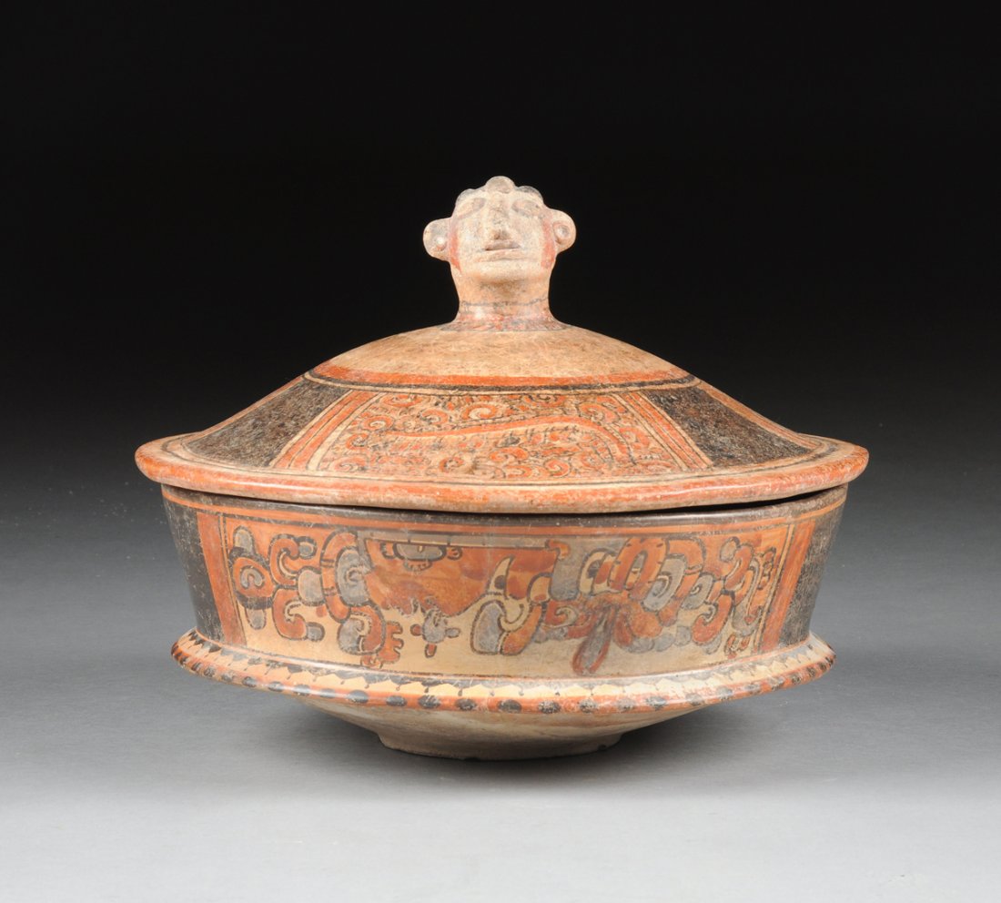 A MAYAN TIKAL POLYCHROME PAINTED POTTERY CEREMONIAL POT: A MAYAN TIKAL POLYCHROME PAINTED POTTERY CEREMONIAL POT WITH ASSOCIATED LID, GUATEMALA, LATE CLASSIC PERIOD, CIRCA A.D. 550-950, of tapering circular form with sides centering bifurcated details befor