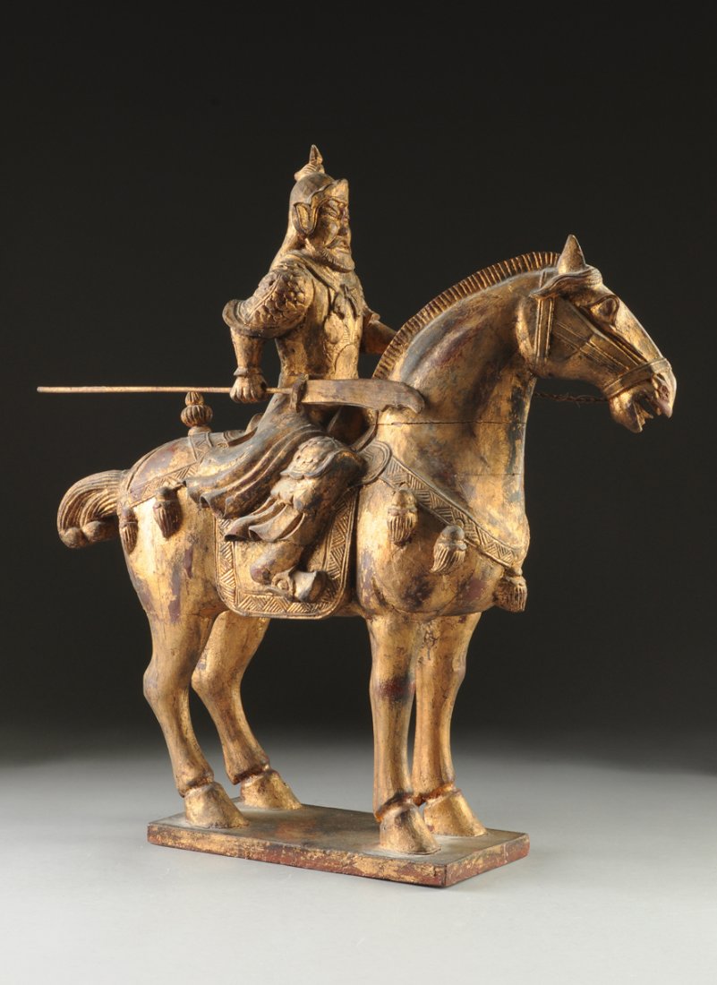 A CHINESE TANG DYNASTY STYLE PARCEL GILT CARVED WOOD: A CHINESE TANG DYNASTY STYLE PARCEL GILT CARVED WOOD EQUESTRIAN WARRIOR GROUP, 20TH CENTURY, the warrior wearing traditional armor and holding a Guan Dao (polearm) in one hand and rope reigns in the o