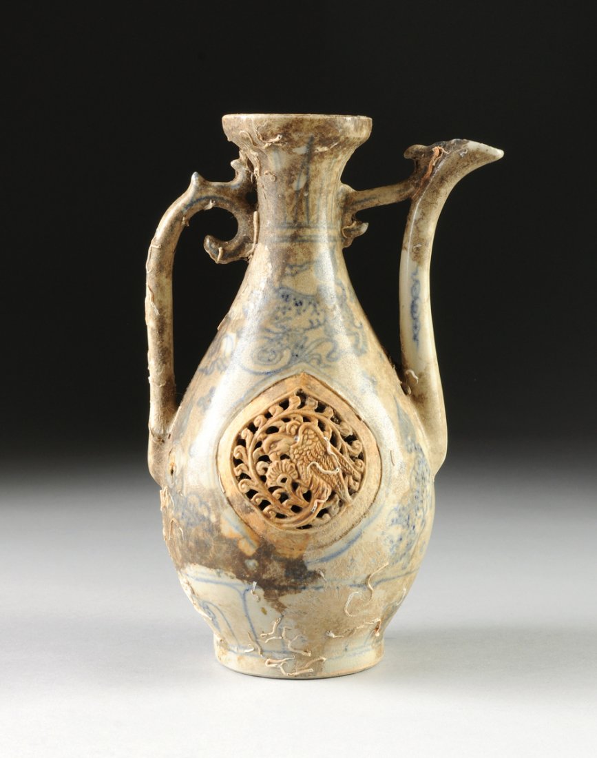 A VIETNAMESE/ANNAMESE BLUE AND WHITE PEAR FORM EWER,: A VIETNAMESE/ANNAMESE BLUE AND WHITE PEAR FORM EWER, 15TH/16TH CENTURY, With sides centering an unglazed and reticulated ogival panel modeled as a parrot amidst stylized branches beneath a cobalt blue