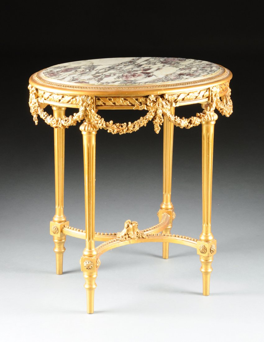 A LOUIS XVI STYLE MARBLE TOPPED AND GILT PAINTED CARVED: A LOUIS XVI STYLE MARBLE TOPPED AND GILT PAINTED CARVED WOOD TABLE DE MILIEU, LATE 19TH/EARLY 20TH CENTURY, the oval Bréche Viollete marble top, above a ribbon and acanthus leaf wrapped rod detailed 